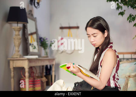 Woman reading novel at home Stock Photo
