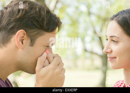Couple together outdoors, man kissing woman's hand Stock Photo