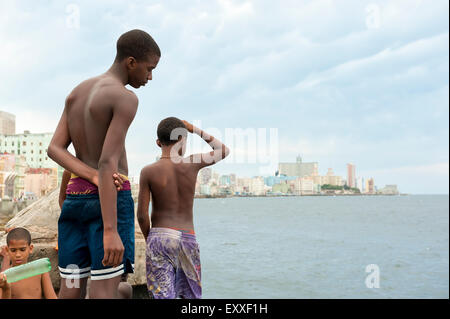 HAVANA, CUBA - MAY, 2011: Young Cubans gather on the wall of the Malecon to take turns jumping in the sea. Stock Photo