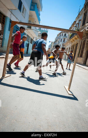 HAVANA, CUBA - JUNE 13, 2011: Young Cubans play a game of soccer on the streets of Centro. Stock Photo