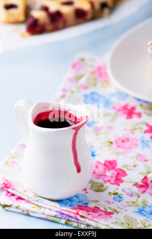 Berry sauce in white milk jug, selective focus Stock Photo