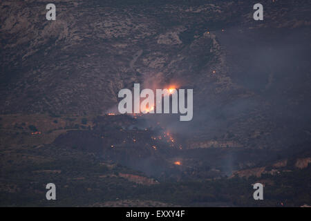 Athens, Greece. 17th July 2015. The fires on the slope of the Hymettos mountain range are still visible from Athens through the night. The smoke coming from the wildfires in the Hymettos mountain range near Athens have visibly died down during the evening and early night. The fires however continue to burn through the night and are visible from Athens. Credit:  Michael Debets/Alamy Live News Stock Photo