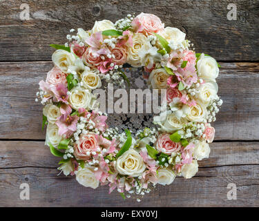 Roses wreath on wooden background. Stock Photo