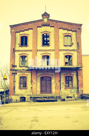 Vintage photo of old abandoned building with windows in old town. Stock Photo