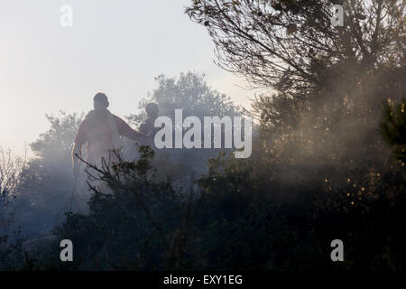 Athens, Greece. 17th July, 2015. Volunteers try to put out the fire. Large fire burst in mountain Hymettus and spread fast because of strong winds. The fire burned houses and stores and left at least one dead due to respiratory problems. Credit:  Kostas Pikoulas/Pacific Press/Alamy Live News Stock Photo