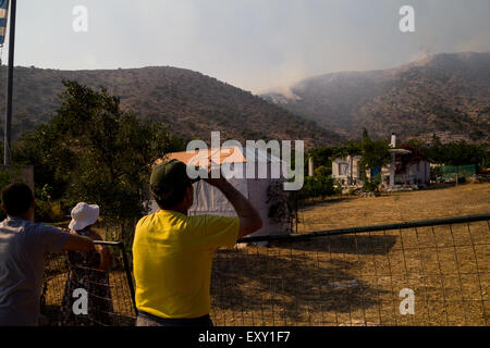 Athens, Greece. 17th July, 2015. People watch the fire worrying about their residence. Large fire burst in mountain Hymettus and spread fast because of strong winds. The fire burned houses and stores and left at least one dead due to respiratory problems. Credit:  Kostas Pikoulas/Pacific Press/Alamy Live News Stock Photo