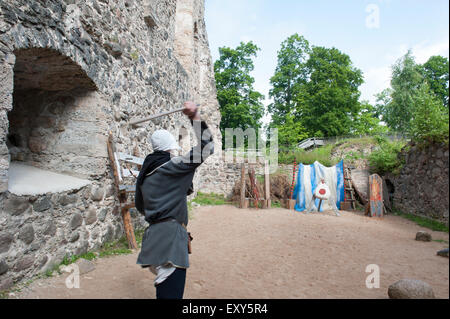 An interpreter demonstrating how to throw a spear at the Livonian Order Sigulda Castle in Latvia. Stock Photo
