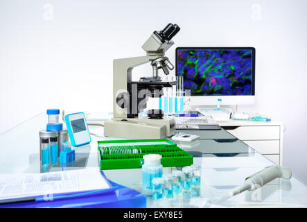 Microscopic work station. Microscope, computer monitor with digital fluorescent image and tools for histological staining of tis Stock Photo