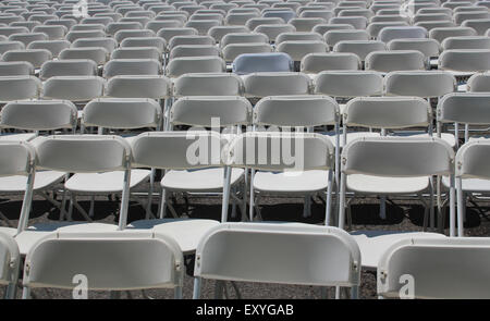 Rows of white empty folding chairs at a concert, wedding, festival or ceremony Stock Photo