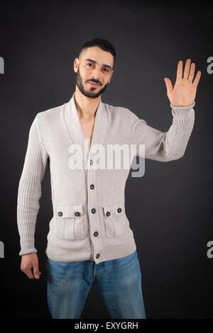 Handsome man doing different expressions in different sets of clothes: waving Stock Photo