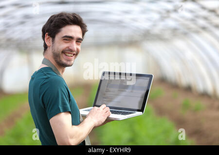 View of a Young business farmer working on his laptop Stock Photo