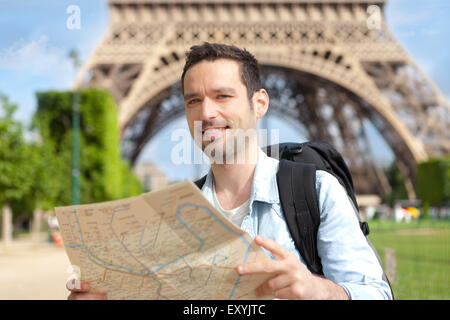 Young attractive tourist reading map in Paris, France Stock Photo