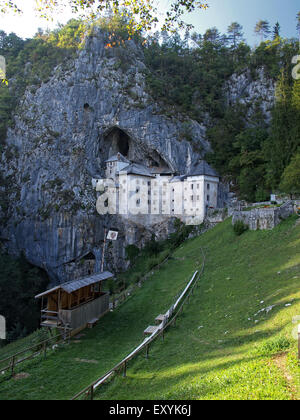 View of Predjama castle, a renaissance castle built in a cave, with a field for medieval tournaments, near Postojna. Slovenia. Stock Photo