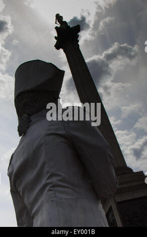 London, July 18th 2015.  A living statue stands in the shadow of Nelson's columnduring the  Busk in London Festival aimed at showcasing the outstanding talents of many of the capital's finest street performers, including, musicians, magicians, living statues and bands. Credit:  Paul Davey/Alamy Live News Stock Photo