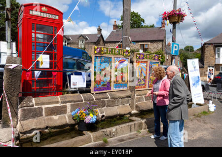 Market Place, Crich, Derbyshire, U.K. 18th July 2015. The first ever well dressing in the Derbyshire village of Crich. Well dressing is a popular tradition in Derbyshire, but this is the first year Crich has participated in well dressing. The origin of well dressing is said to lie in pagan tradition or in giving thanks for the purity of the water drawn from wells during the time of the Black Death. It is believed to have originated in the Derbyshire village of Tissington in 1349. Credit:  Mark Richardson/Alamy Live News Stock Photo