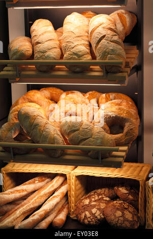 Various kinds of fresh baked bread on the shelves in the bakery. Shallow focus.