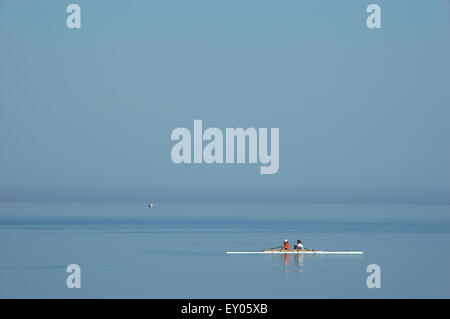 Young rowing athlets crew of NOL (Nautical club of Lemnos) pulling the oars. Romeikos bay, Limnos island, Greece Stock Photo