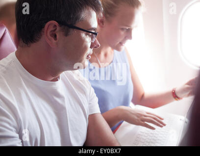 People with Laptop on a Plane Stock Photo