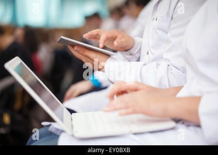 Medical students with pad and laptops in auditorium Stock Photo