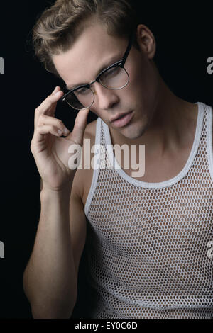 A good looking blond hair male model, wearing vintage eye glasses, looking down thinking, and posing. A vintage portrait concept Stock Photo