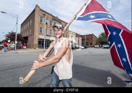 Graham, North Carolina, USA. 18th July, 2015. Rally participant walks with a huge Confeserate Flag as people gathered at the historic Alamance County courthouse in support of the Confederate monument during the 'Rally For Our Monument' in downtown Graham. © Sean Meyers/ZUMA Wire/Alamy Live News Stock Photo