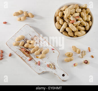 Peanuts in shells on   white wooden background. Top view Stock Photo