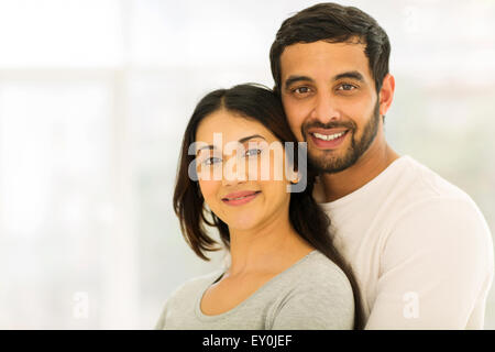 romantic young Indian couple hugging indoors Stock Photo