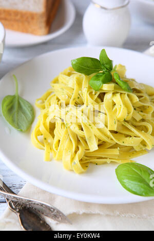 Delicious pasta with pesto on plate on table close-up Stock Photo - Alamy