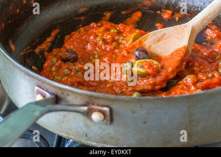 Freshly cooked tomato sauce for pasta with olives, capers and anchovies a la Puttanesca Stock Photo