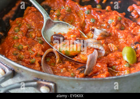 Freshly cooked tomato sauce for pasta with olives, capers and anchovies a la Puttanesca Stock Photo