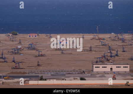 Pump jacks in oil wells at the shore of the Caspian sea at the suburbs of the city of Baku capital of Azerbaijan Stock Photo