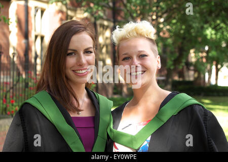 Two female graduate students wearing gowns for their graduation ceremony day at University of Leeds July 2015 Stock Photo