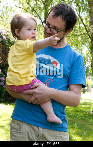 Baby girl being held by her father pointing Stock Photo