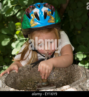 A thirsty child drinking from a water fountain in a New York park Stock Photo