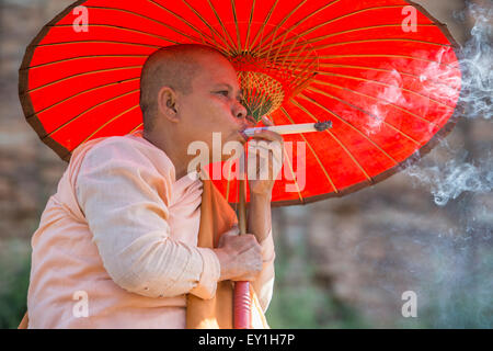 Nun smoking whacking white cheroot, Myanmar Stock Photo