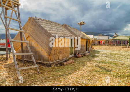 Hand made houses in Uros with solar panels, artificial islands made of floating reeds, Peru, South America. Stock Photo