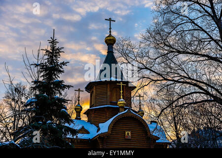 Old Russian style church made of logs at winter sunset. Stock Photo