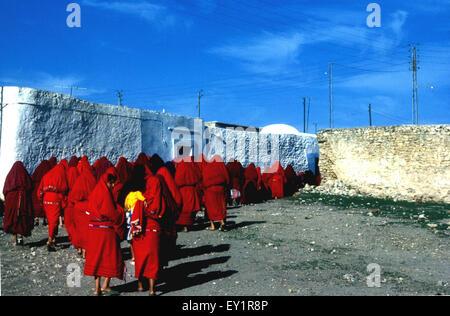 Village women wearing red haiks follow a funeral in rural Tunisia Stock Photo