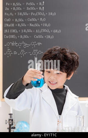 Boy holding glassware and looking away with smile Stock Photo