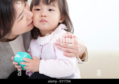 Mother kissing baby girl with smile, Stock Photo