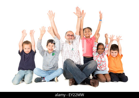 Group of children and teacher with raised hands isolated in white Stock Photo