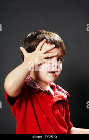 Portrait of young boy with hand on face Stock Photo