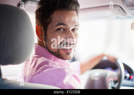 Portrait of young businessman looking over his shoulder in car Stock Photo