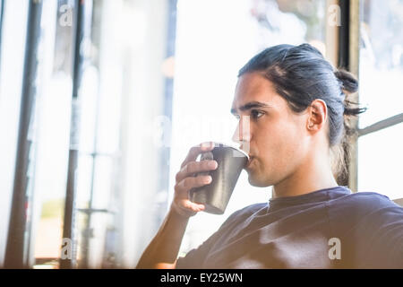 Young man drinking coffee, indoors Stock Photo