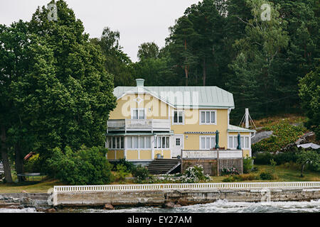 Yellow painted timber house, waterfront, Stockholm archipelago in summer, Sweden Stock Photo