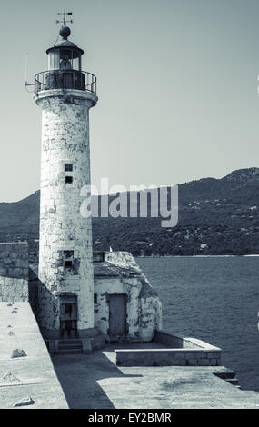 White lighthouse tower. Entrance to Propriano port, Corsica island, France. Monochrome toned, retro stylized photo Stock Photo