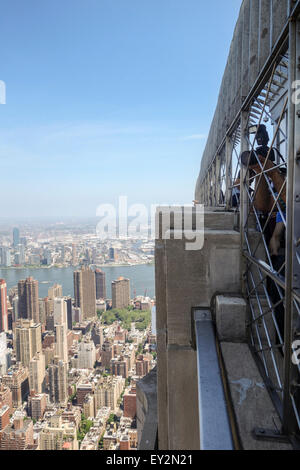 Tourists on top of Empire State Building, 86th floor Observation Deck, viewing Manhattan, New York City, USA. Stock Photo