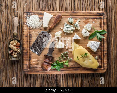 Different types of cheeses with nuts and herbs. Top view. Stock Photo