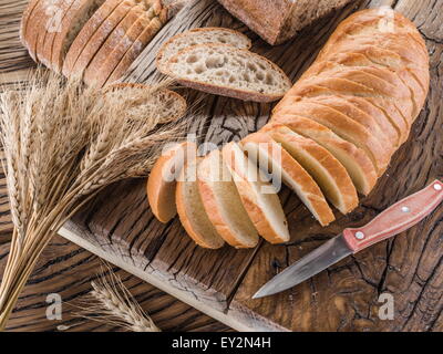 Sliced white bread on the old wooden plank. Stock Photo