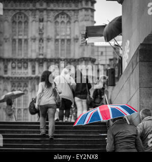 A Union Jack umbrella in front of the Houses of Parliament on a rainy day in London Stock Photo